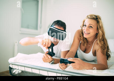 Attractive couple enjoying playing games with vr goggles Stock Photo