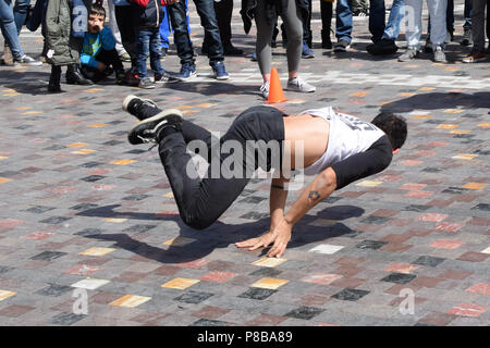 ATHENS, GREECE - APRIL 1, 2018: Young man breakdancing in public square. Urban street dance youth culture. Stock Photo