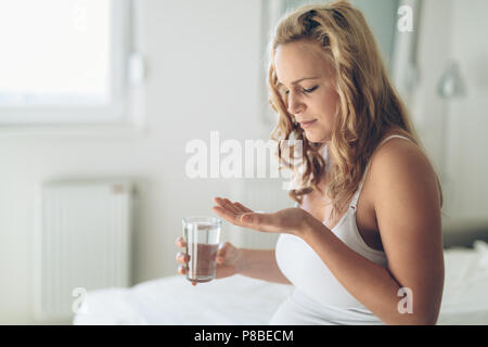 Picture of pregnant woman taking medication pills Stock Photo