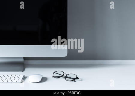 glasses and computer mouse with keyboard on working table Stock Photo