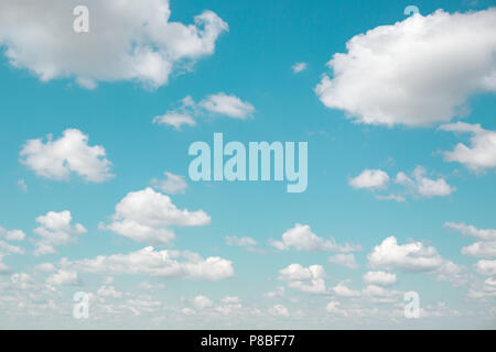 Background of white fluffy clouds and blue sky with vintage filter. Gradient celestial azure cloudscape. Good weather. Stock Photo