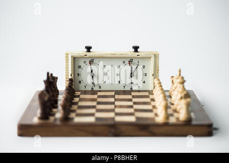 Chess clock and chess board with figures set for new game isolated on white Stock Photo