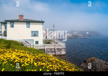 Fog drifting off of Trinity Bay over the town of Trinity on the Bonavista Peninsula in Newfoundland Stock Photo