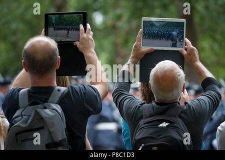 On the 100th anniversary of the Royal Air Force (RAF) and before an historic flypast of 100 aircraft formations representing Britain's air defence history which flew over central London, the public watch a march past of service personnel, on 10th July 2018, in London, England. Stock Photo