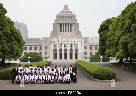 TOKYO, JAPAN - MAY 9, 2012: School trip group poses for a photo in front of National Diet Building in Tokyo. The building is the headquarters for two  Stock Photo