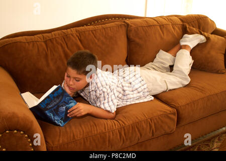 Boy reading book on sofa in family room. MR  © Myrleen Pearson. ....Ferguson Cate Stock Photo