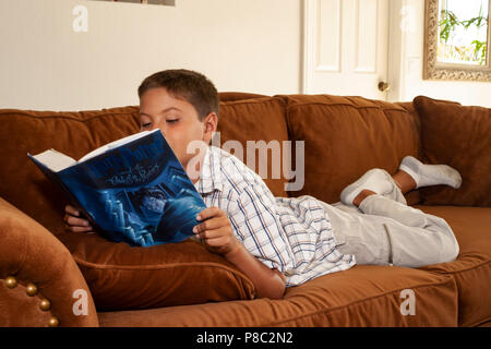 Boy reading book on sofa in family room. MR  © Myrleen Pearson.   ......Ferguson Cate Stock Photo