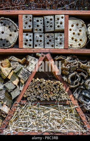 Bee and insect house made from natural materiels such as straw, wood, bark and fir cones. Stock Photo