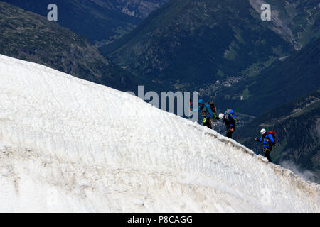 Mountain climbers reaching the top of the Aiguille-du-Midi on their way to the summit of Mont Blanc in France Stock Photo