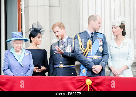 London, UK. 10th July 2018. Prince Harry, Duke of Sussex describes flying to his wife, Meghan, Duchess of Sussex as they watch the flypast from Buckingham Palace Balcony along with other members of the British Royal Family  to commemorate 100 years of the RAF Credit: amanda rose/Alamy Live News Credit: amanda rose/Alamy Live News Stock Photo