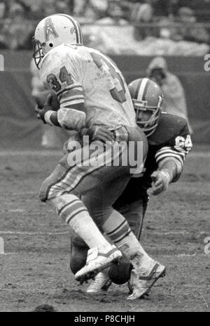 Houston Oiler running back Earl Campbell (34), pops the line for three  yards in the second quarter of the NFL game at Houston, Sunday, Dec. 24,  1979. Houston Oilers David Carter, blocks