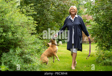 Buechten, Germany. 25th June, 2018. The presenter Alida Gundlach plays with her dog in the garden. Gundlach celebrates her 75th birthday on 17 July. Credit: Philipp Schulze/dpa/Alamy Live News Stock Photo