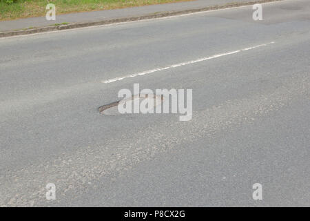 Pot holes in Carterton, Oxfordshire UK. 13th May 2018. UK Weather: Pot holes in West Oxfordshire, multiple potholes on the streets of Oxfordshire. Stock Photo