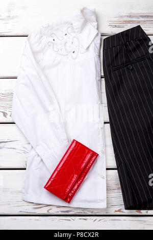 Folded white decorated women blouse and red wallet. Stock Photo