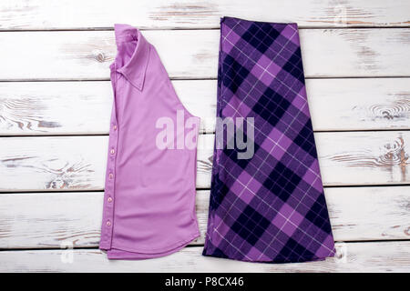 Pink folded shirt and purple checkered skirt. Stock Photo