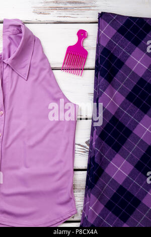 Concept of purple women's clothes and comb. Stock Photo