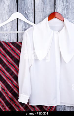 White blouse and shirt on hangers. Stock Photo