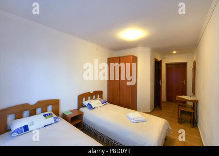 hotel room with two beds wooden wardrobe and table . For your design Stock Photo