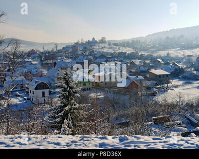 The town in the lowland is covered with a thin layer of the first snow on the background of the distant mountains . For your design Stock Photo