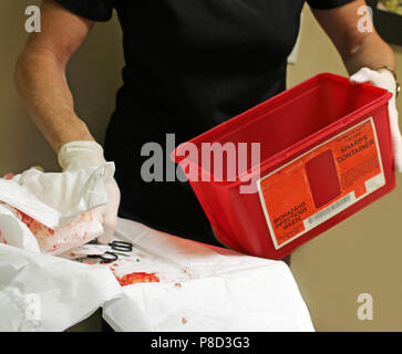 Cleaning up medical waste after a surgery. Stock Photo