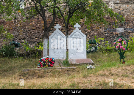 Memorial monuments on the background of tall trees and an ancient stone wall . For your design Stock Photo