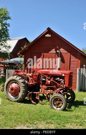 Well maintained, red McCormick Farmall farm tractor parked on farmstead in rural countryside of Wisconsin, USA Stock Photo