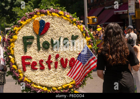 Participants in the 9th Annual Flower Parade (Desfile de las Flores) in the Jackson Heights neighborhood of Queens in New York on Sunday, July 8, 2018. The parade, complete with silleteros, flower sellers, carrying medallions of flowers on their backs like the silleteros who carry them on their backs down the mountains in Colombia around the city of Medellin to sell at market. Stock Photo