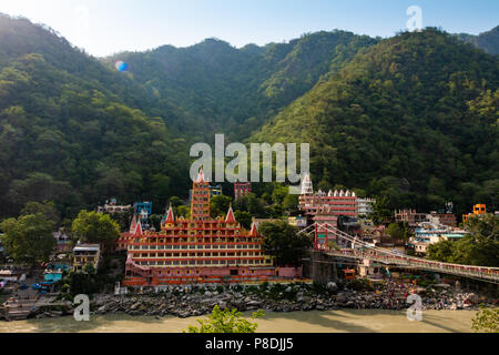 View of Ganga river embankment, Lakshman Jhula bridge and Tera Manzil Temple, Trimbakeshwar in Rishikesh Stock Photo