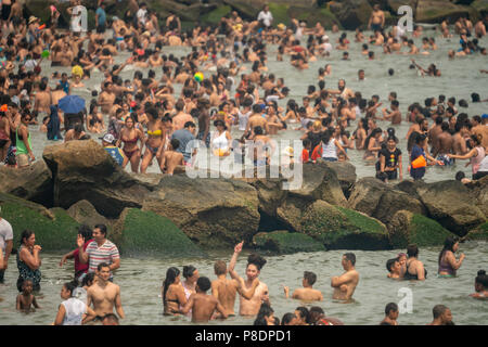 Thousands of beachgoers try to beat the oppressive heat and escape to Coney Island in Brooklyn in New York and literally pack the beach on Sunday, July 1, 2018.  Sunday was the hottest day of 2018, reaching onto the high 90's all over the area, but temperatures are expected to remain in the 90's's all week as a heat wave settles over the city. (Â© Richard B. Levine) Stock Photo