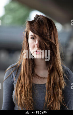 Emotional girl looking straight ahead with saddened eyes. Selective focus. Medium close up. Stock Photo