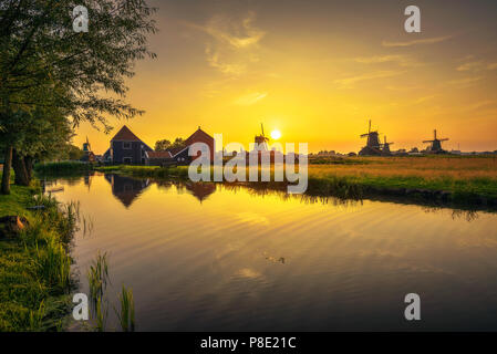 Sunset above farm houses and windmills of Zaanse Schans in the Netherlands Stock Photo