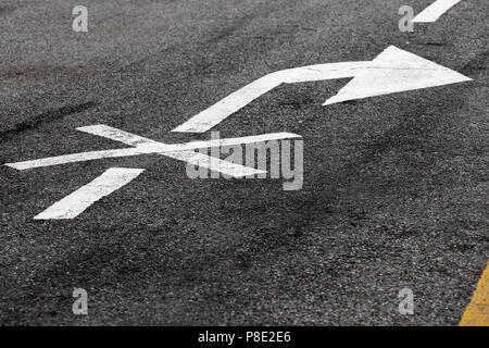 Right turn is prohibited. Crossed white arrow, road marking on dark asphalt. Close-up photo with selective focus Stock Photo