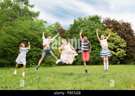 happy kids jumping in summer park Stock Photo