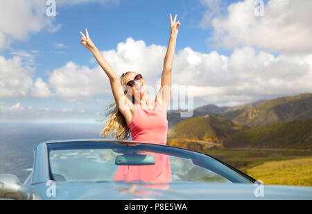 happy woman in convertible car on big sur coast Stock Photo