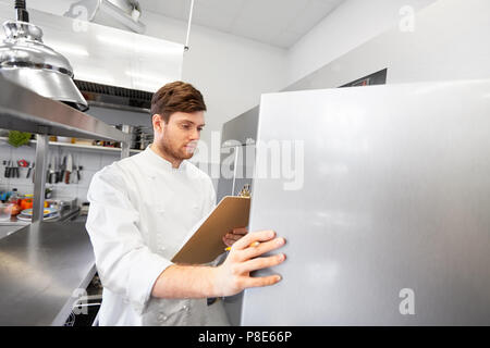 chef with clipboard doing inventory at kitchen Stock Photo
