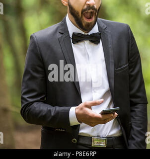 sleepy yawning businessman with smartphone in the Park Stock Photo