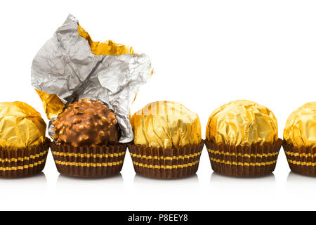 Candy in gold wrappers, isolated on white background Stock Photo