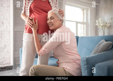 Mother of young expecting woman sitting on comfortable sofa Stock Photo