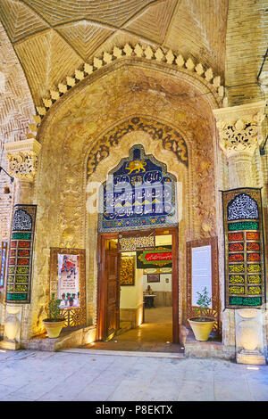 KERMAN, IRAN - OCTOBER 15, 2017: The scenic entrance to Hayati Museum from the Vakil Bazaar, the doorway is decorated with relief patterns and Persian Stock Photo