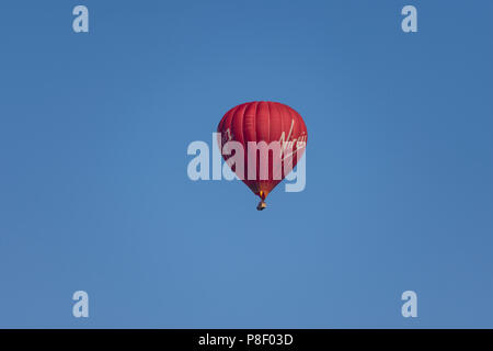 The Virgin hot air balloon in a clear blue sky early on a summers morning. Stock Photo