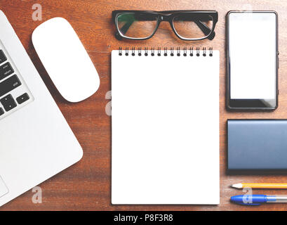 Business essentials. Top view of spiral blank notebook on wood desk background Stock Photo