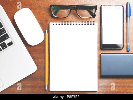 Business essentials. Top view of spiral blank notebook on wood desk background Stock Photo