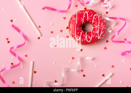 Donuts with icing on pastel pink background with copyspace. Sweet donuts. Stock Photo