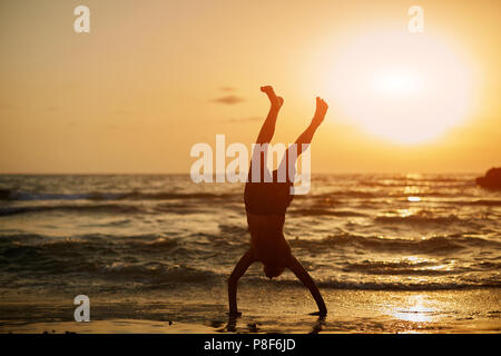 Yoga woman in serene sunset at beach doing pose Stock Photo by ©Maridav  25235133