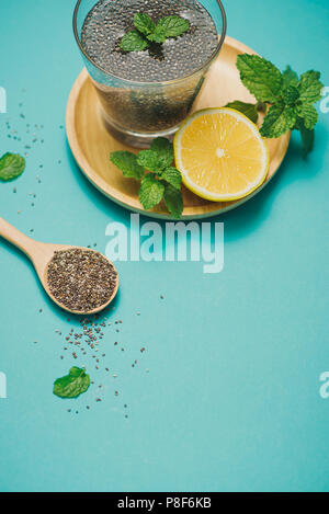 Selective focus of chia seeds drink with water in transparent glass with lemon balm. Stock Photo