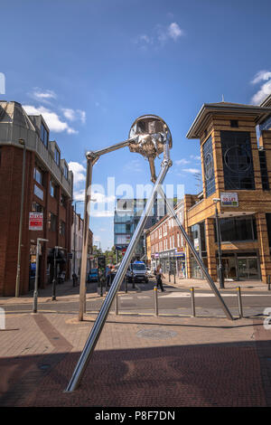 Metallic sculpture in Crown Square of a Martian tripod invader from H G Wells' classic novel War of the Worlds, which is set in Woking, Surrey, UK Stock Photo