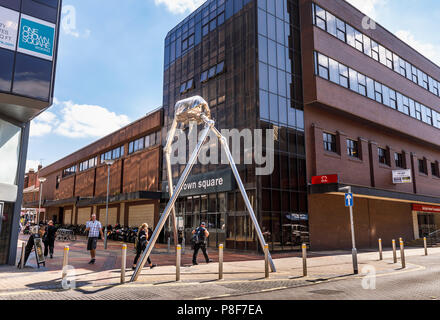 Metallic sculpture in Crown Square of a Martian tripod invader from H G Wells' classic novel War of the Worlds, which is set in Woking, Surrey, UK Stock Photo
