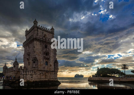 Tourists visit the famous Belem Tower near Lisbon with beautiful sunset over Atlantic Ocean Stock Photo