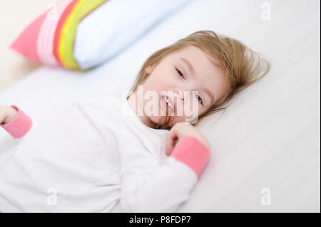 Little preschooler girl in pajamas on sunny morning Stock Photo