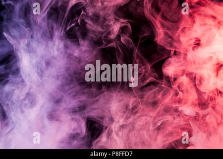 Dense multicolored smoke of   pink, red and purple colors on a black isolated background. Background of smoke vape Stock Photo